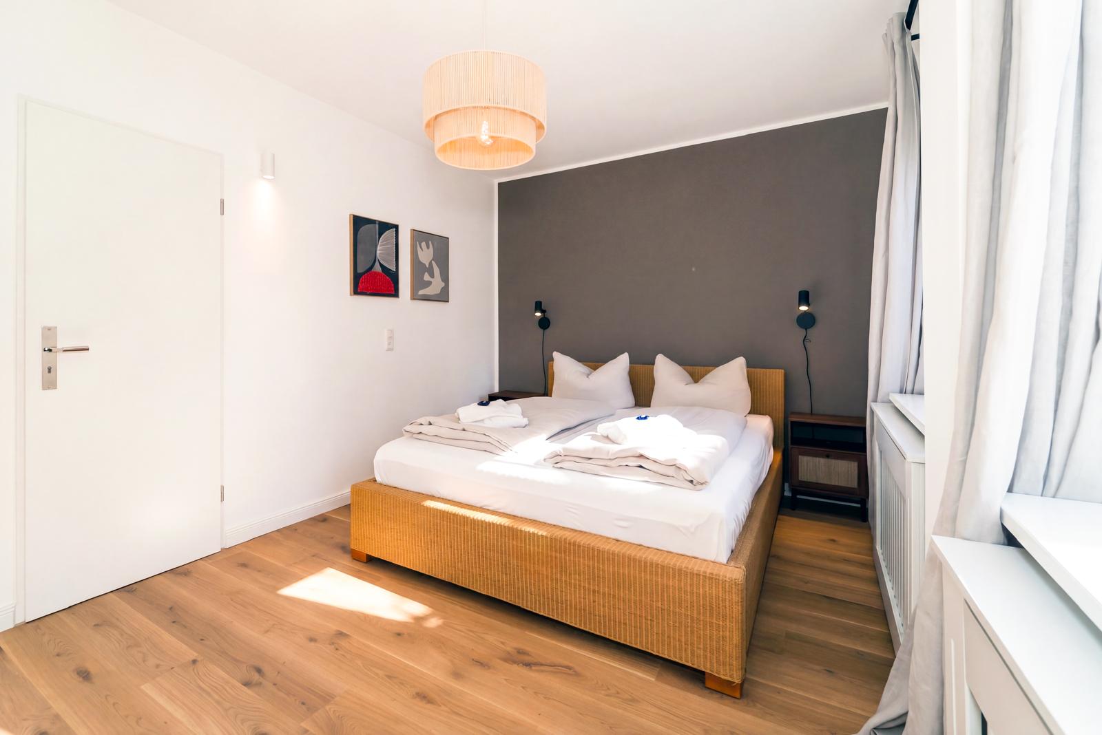 Schlafzimmer mit Doppelbett und Rattan-Kopfteil
