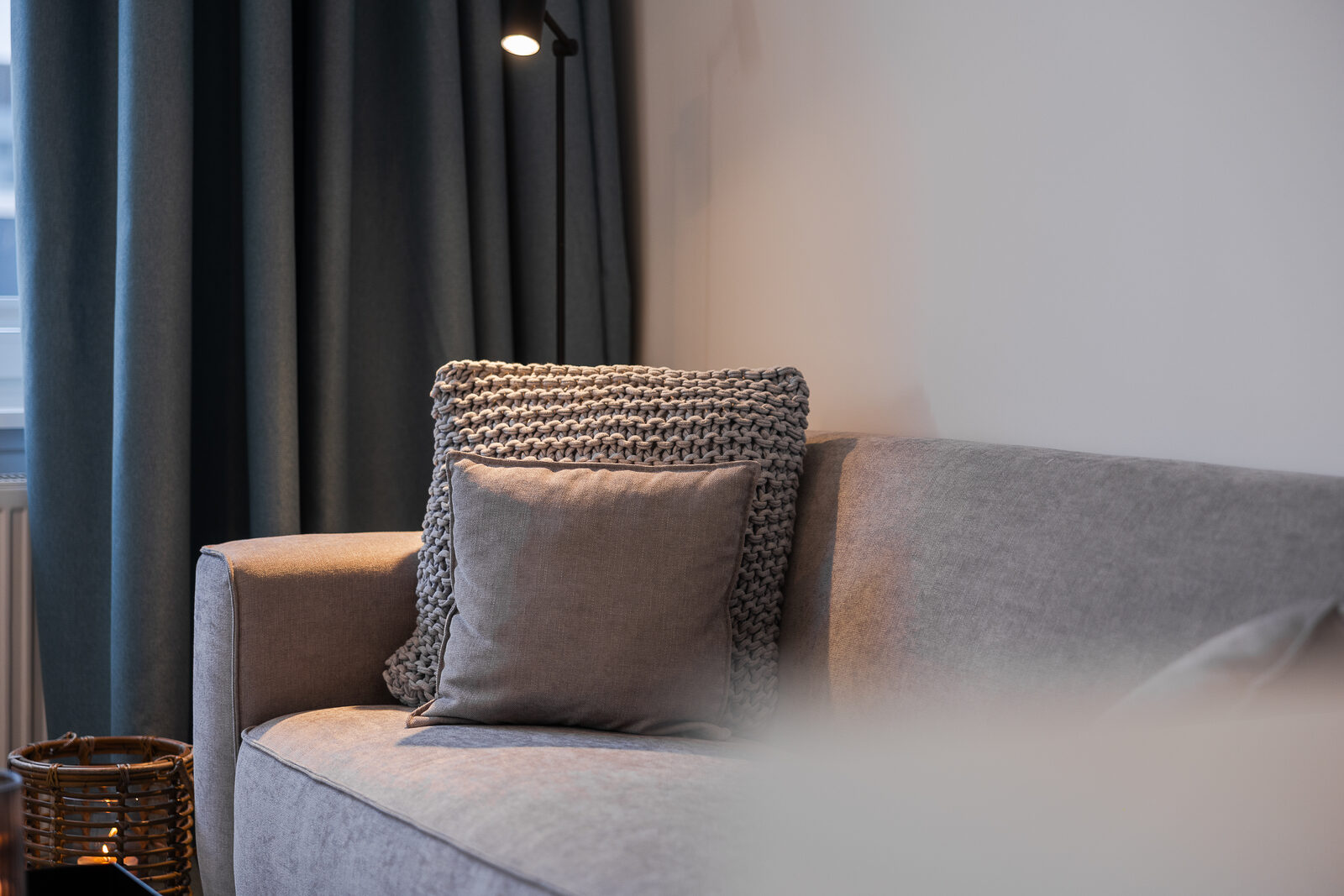Sofa-Detail mit Kissen und Vorhang