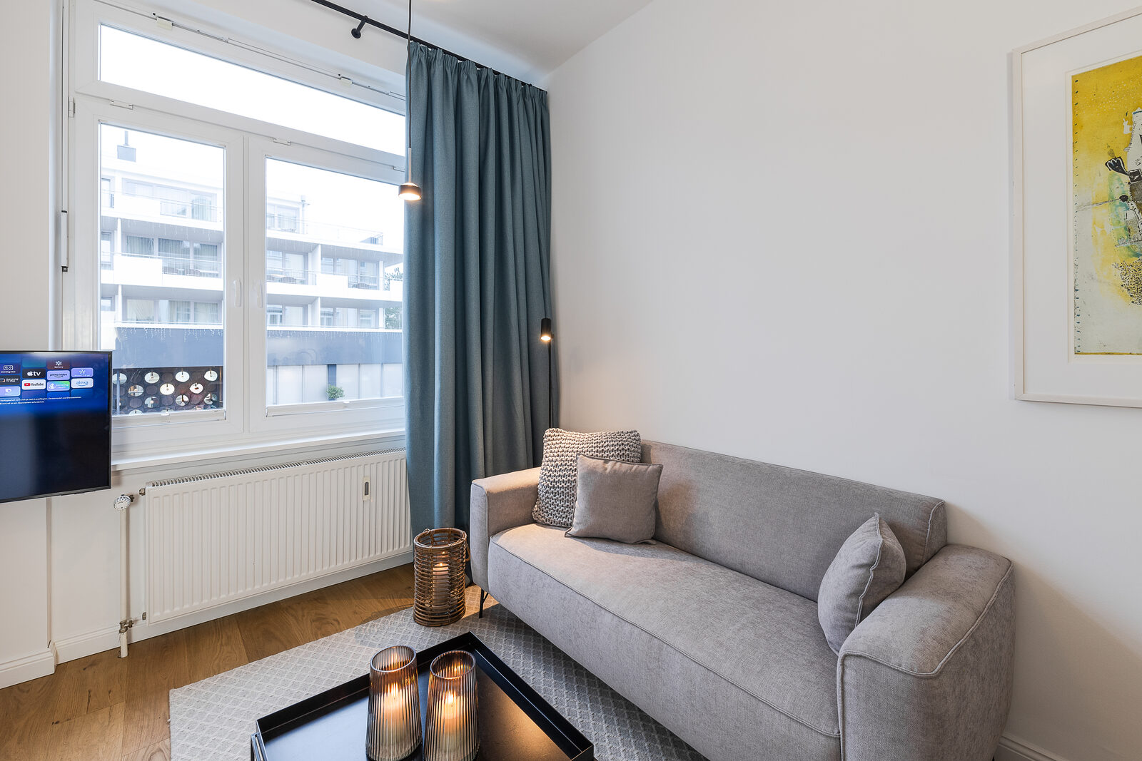 Wohnbereich mit Sofa, Fernseher und Kerzenlicht
